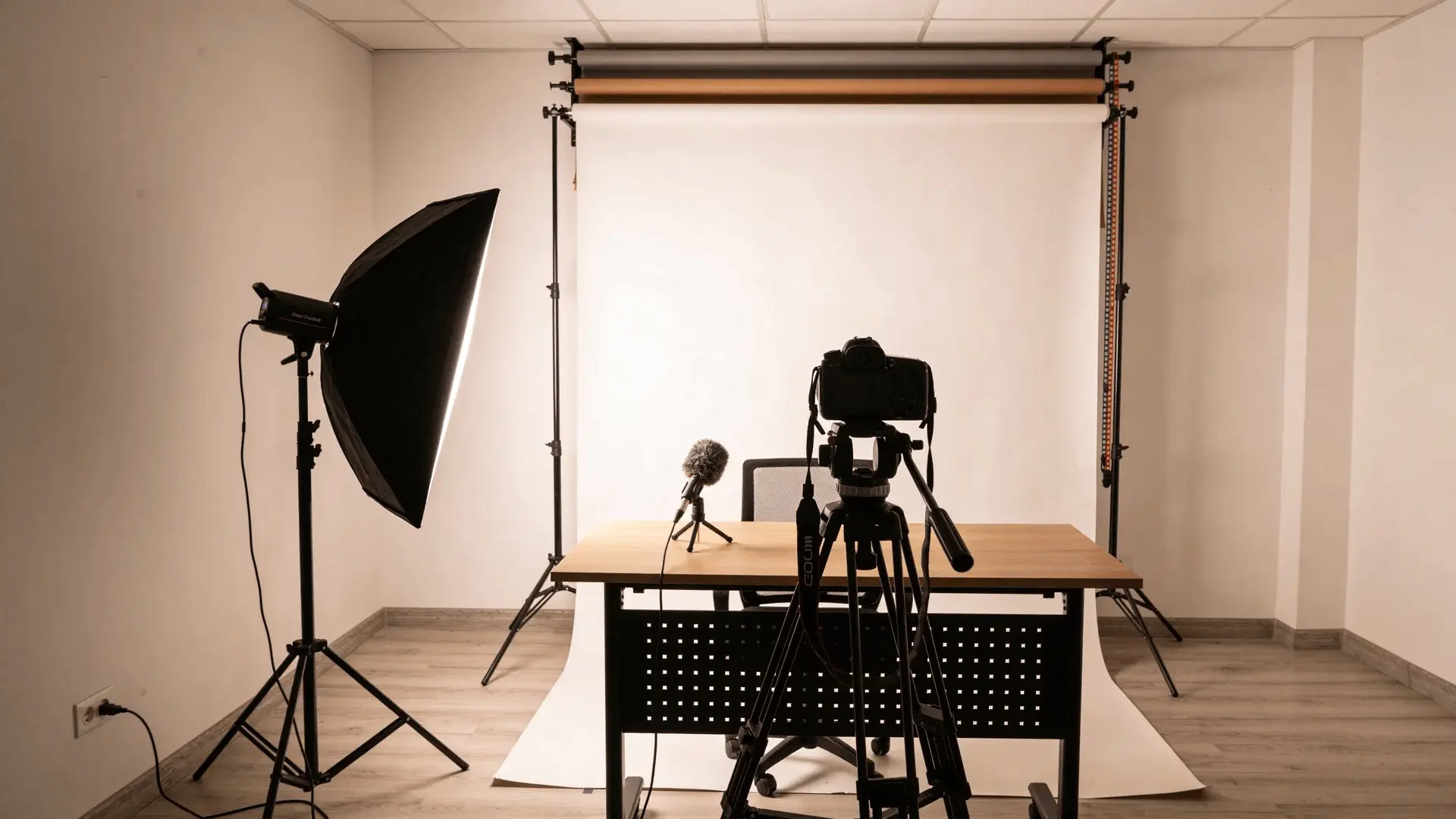 Camera on tripod, microphone, softbox light, and laptop arranged as a training video recording setup