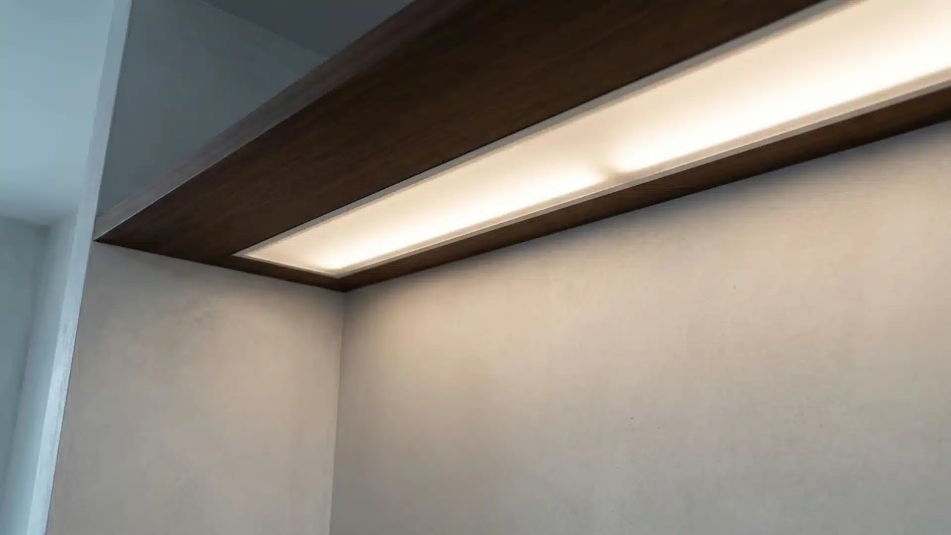 hidden LED strip lighting behind shelf casting indirect glow on wall
