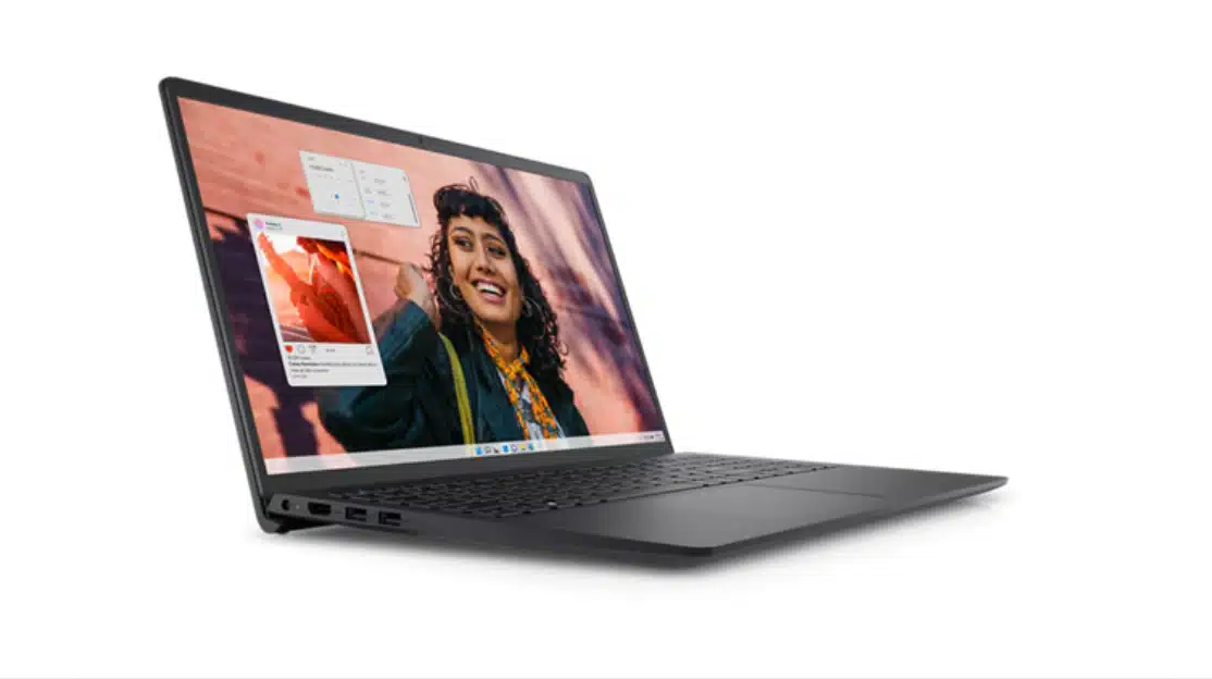 Dell Inspiron 15 laptop open showing display with user interface and person on screen in lifestyle setup