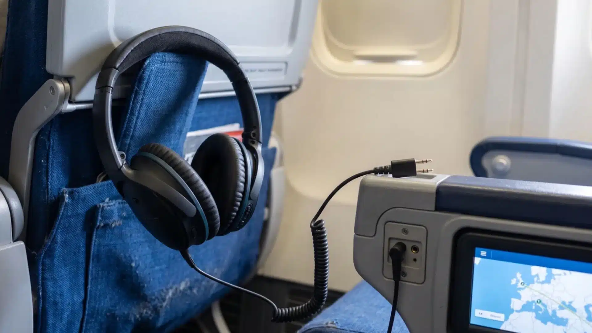 over-ear headphones connected to airplane seat audio jack for in flight listening
