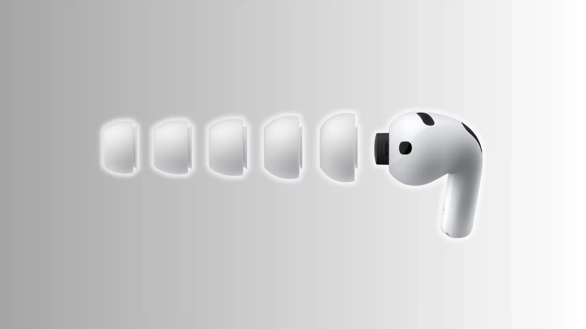 wireless earbud with multiple silicone ear tips shown in increasing sizes beside earbud on grey gradient background