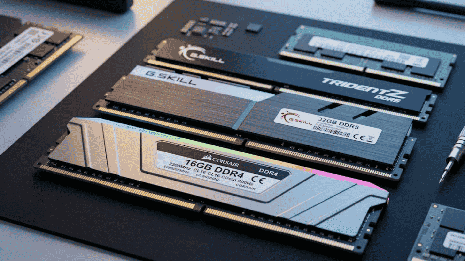 Multiple high-performance computer RAM sticks, including DDR4 and DDR5 memory modules, arranged on a black mat.