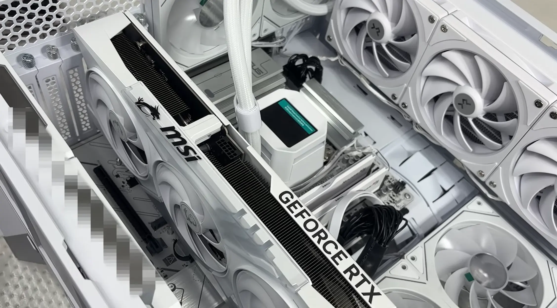 GeForce RTX graphics card installed inside a white custom PC with liquid cooling and multiple case fans.
