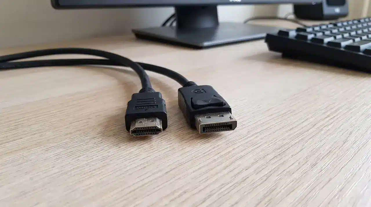 HDMI cable connector and DisplayPort cable connector side by side on a desk
