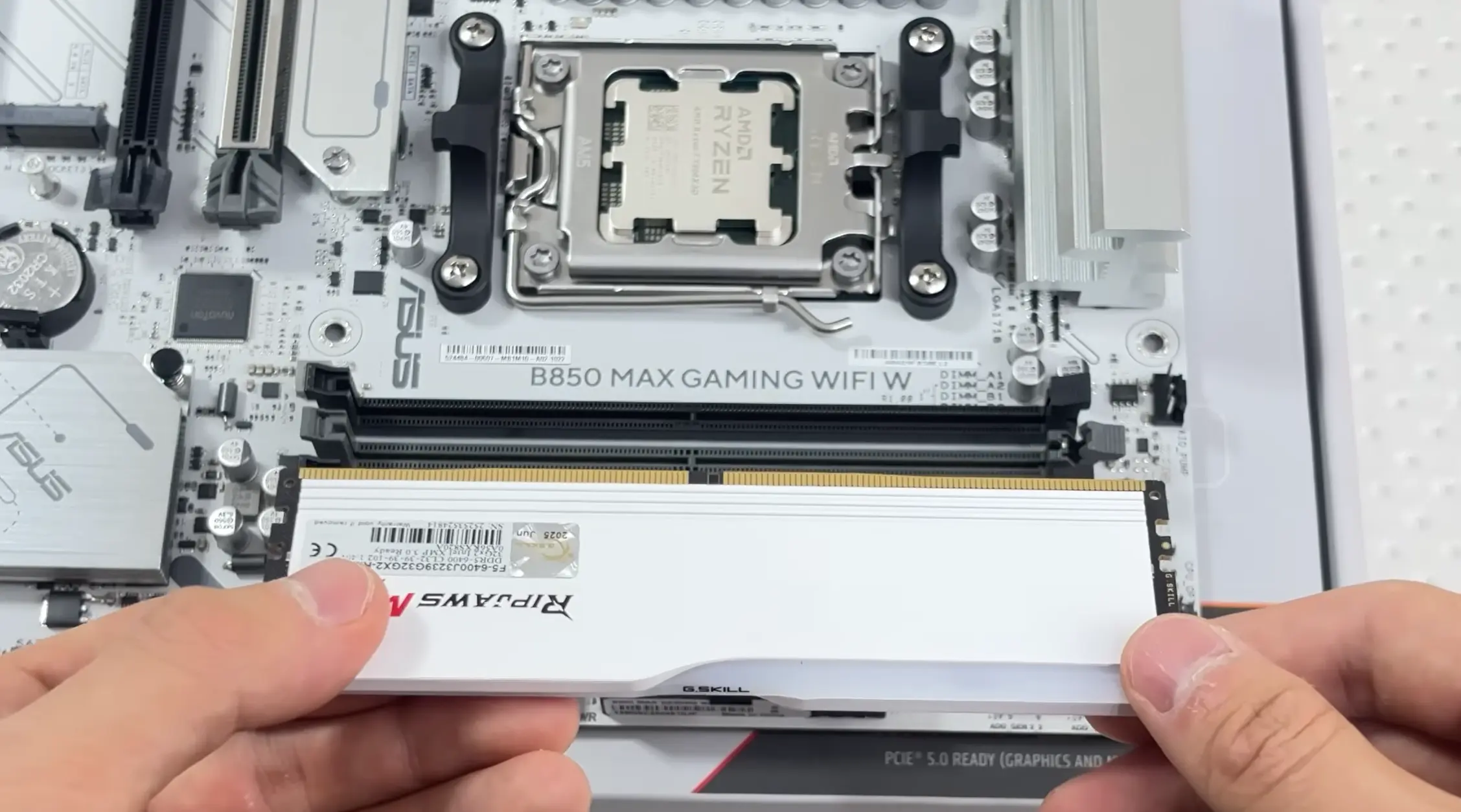RAM module being aligned with a motherboard DIMM slot during a custom PC build.