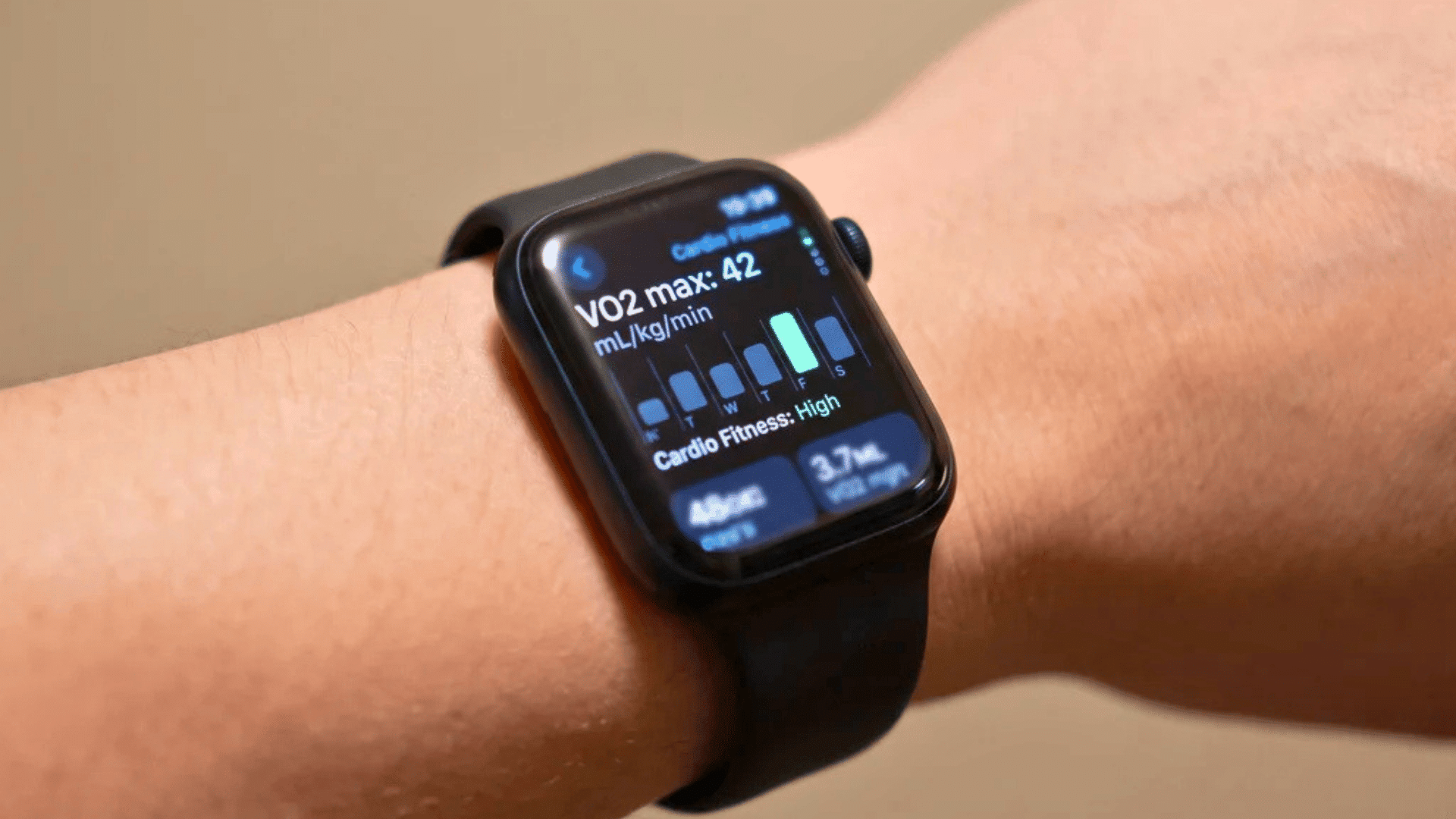 Hand wearing a square smartwatch with a VO2 max reading visible on the display.